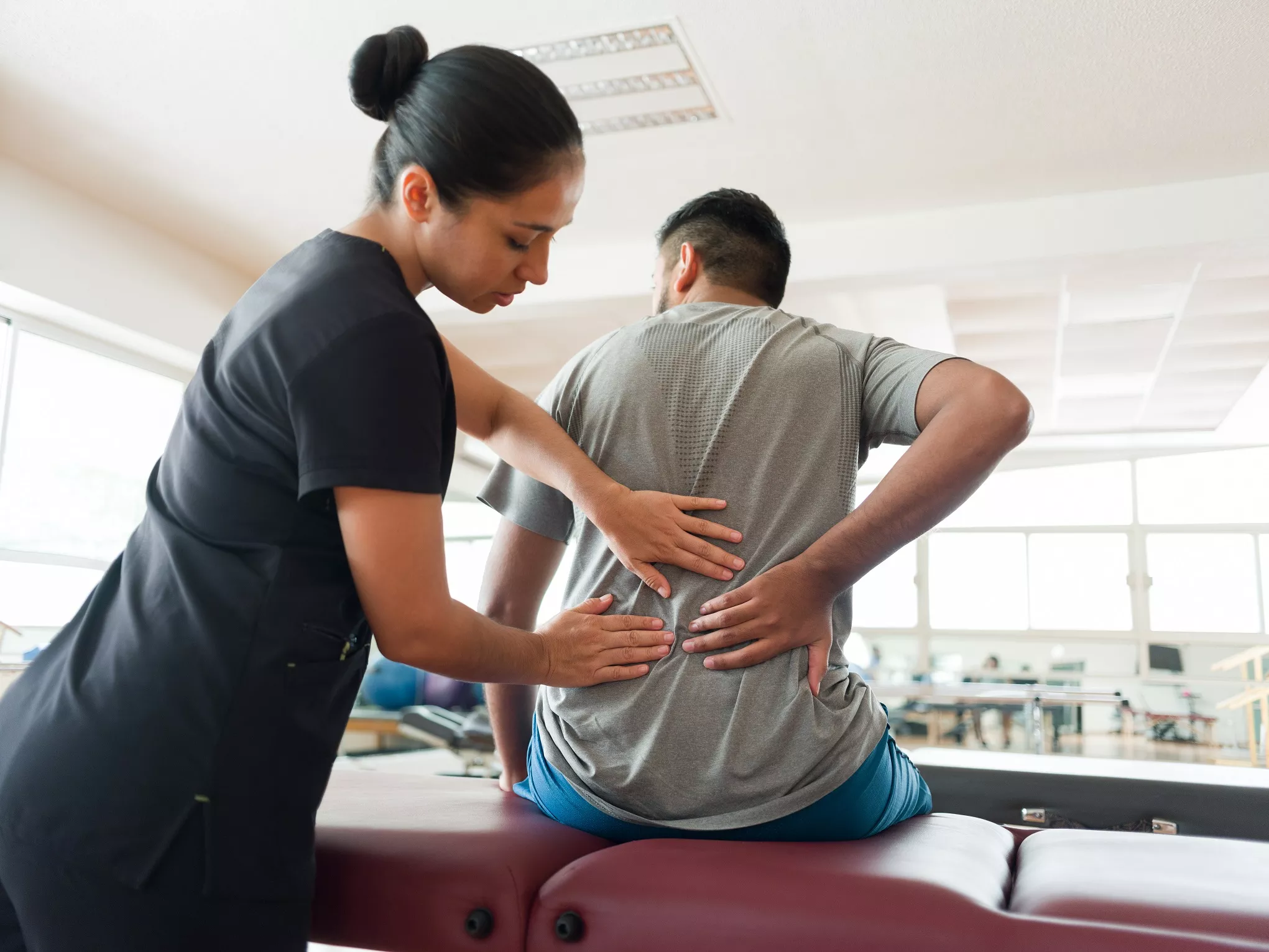 Physical therapist locating patient's back pain